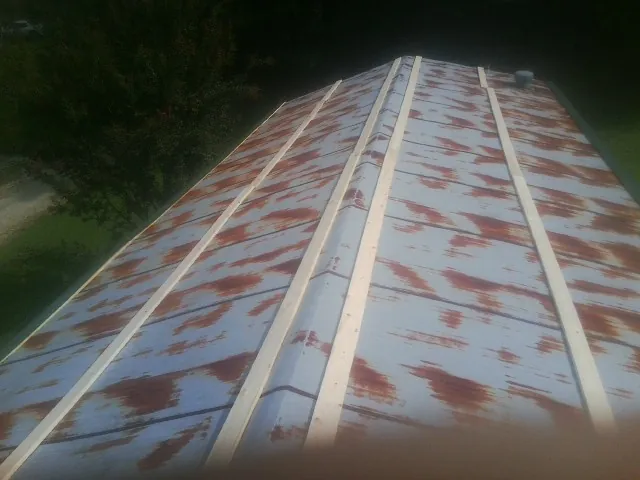 Rusted metal roof panels with new wood purlins before replacement — Storm Damage Roof Repair in Pleasant Hill by Roofing Brothers